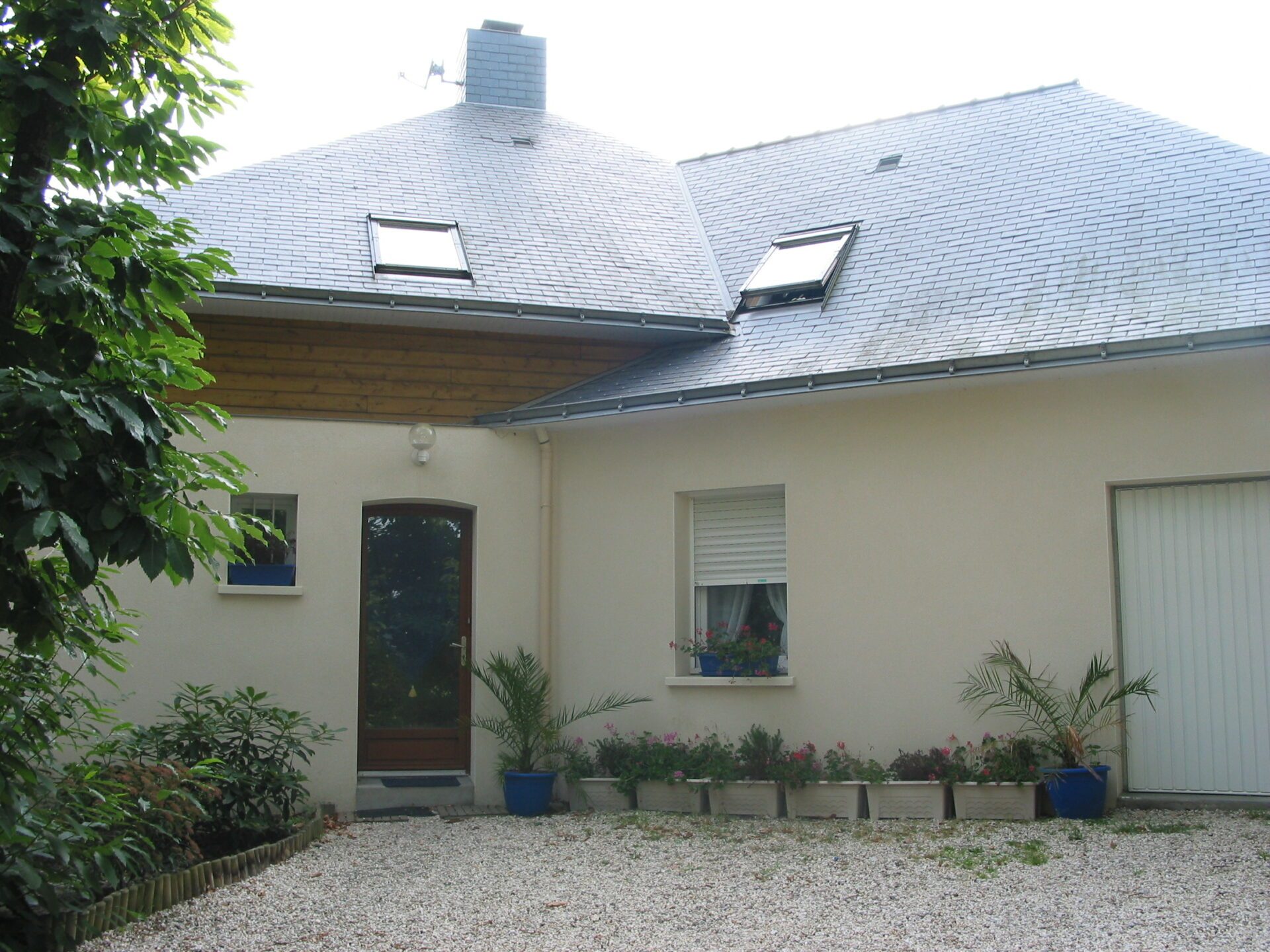 Maison avec bardage bois et grandes baies vitrées ainsi qu'une toiture en ardoise
