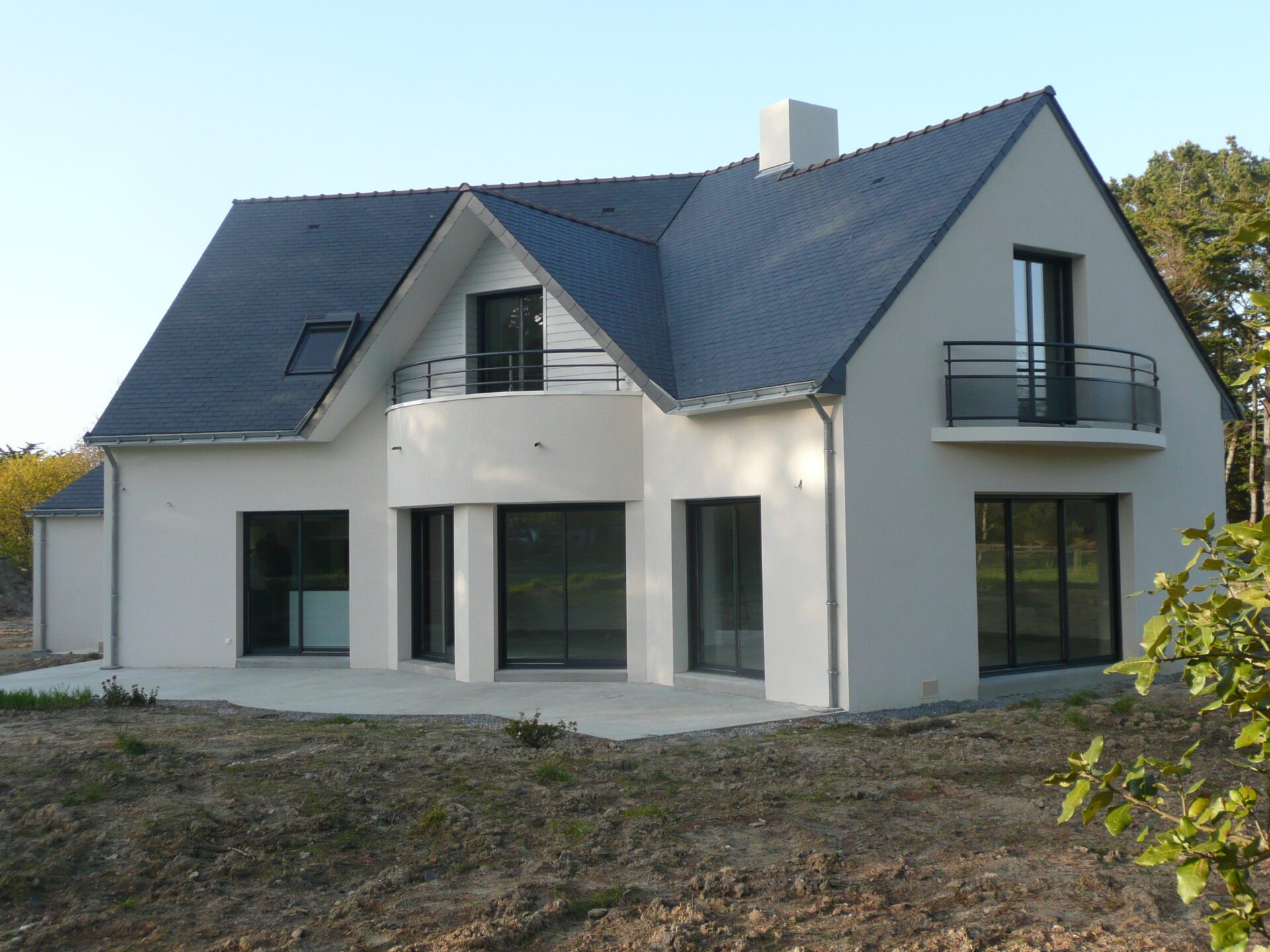 Maison avec toiture en ardoise et grandes baies vitrées