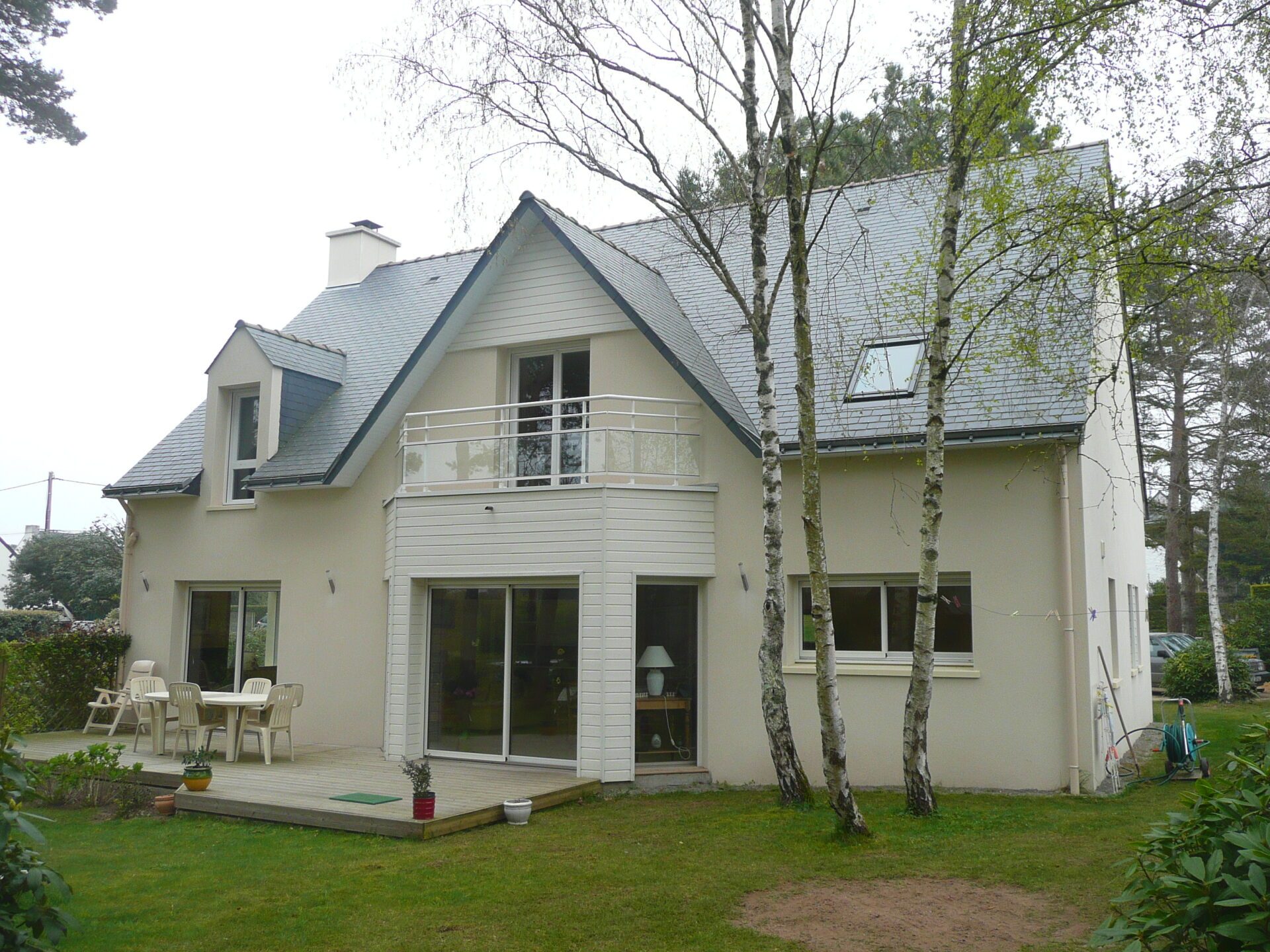 Maison avec bardage aluminium et grandes baies vitrées ainsi qu'une toiture en ardoise